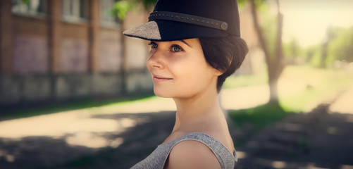 Beautiful girl in a black cap. Portrait of a girl.