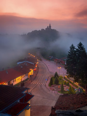 Amazing beautiful view over Tsarevets Fortress in Veliko Tarnovo, Bulgaria on a foggy sunrise in summer.