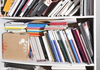 many different books on the shelves, in an open cupboard