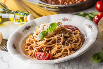 Spaghetti bolognese with ingredients basil tomatoesparmesan cheese and olive oil