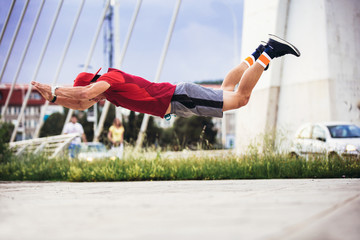 Young man in sporty wear alone working out doing extreme pushups