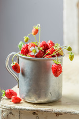 Delicious and fresh wild strawberries on the old white chair