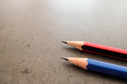 Two pencils on a dark gray table