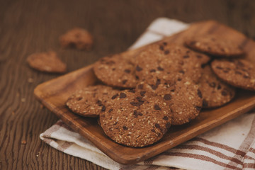 Still life of freshly baked chocolate chip cookies on plate on table.