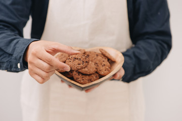 Homemade chocolate cookies on plate in male hands.