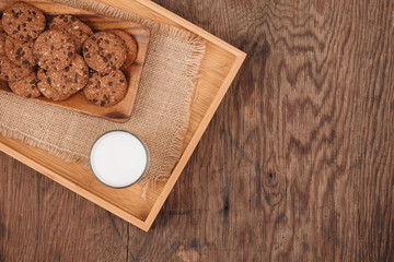 Delicious chocolate chip cookies on a tray on dark old wooden table