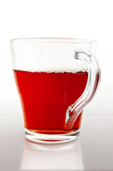 Glass cup of tea on a gradient light gray background vertically.