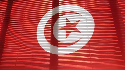 Tunisian flag is hanging at wide jalousie window.