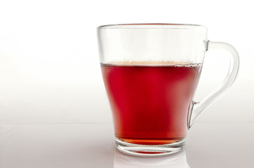 Glass cup of tea on a gradient light gray background.