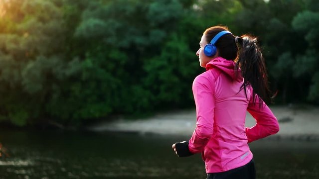 A morning jog in the Park near the pond in the Sunny rays of dawn, the girl is preparing to Mariano and lead a healthy lifestyle