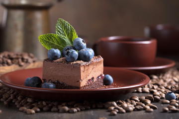 Chocolate cake on a old wooden table with coffee beans.