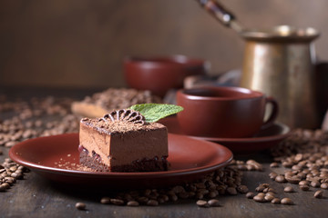 Chocolate cake on a old wooden table with coffee beans.