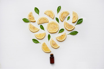 Lemon essential oil with fresh lemon and leaf.