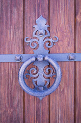 metal forged handle on a background of boards with beautiful structure in frost