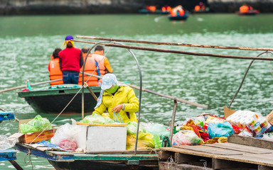 HALONG, VIETNAM - DECEMBER 16, 2016: People on boats in Halong bay. Copy space for text.