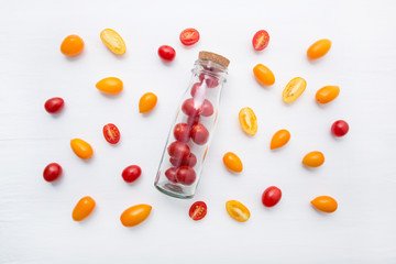 Red and yellow cherry tomatoes on a white background