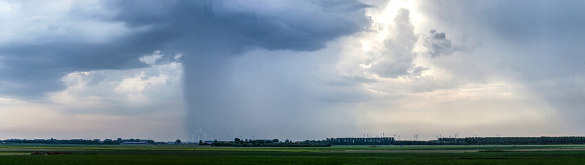 Fototapeta na wymiar Dramatic skies with thunderstorms are moving across the flat landscape of the island of Flakkee, The Netherlands