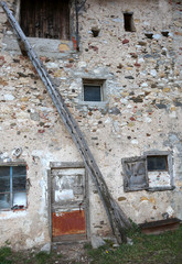 wooden ladder leaning against the wall of the old stable