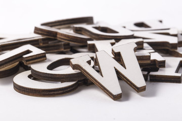 Alphabet letters on wooden scrabble pieces, isolated on white.
