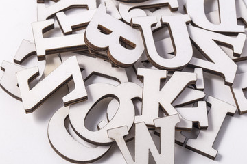 Alphabet letters on wooden scrabble pieces, isolated on white.