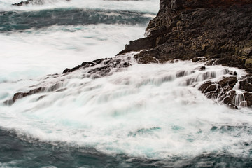 The wild Atlantic Ocean crashes against the rocks along the Western shore of Shetland Islands at Eshaness