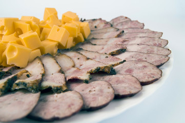homemade sausage and bacon with a large mountain of raw sliced ​​cubes on a plate