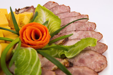 homemade sausage, bacon and hard cheese, laid out in a white plate on a light background