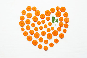 Chopped carrot slices heart shape and parsley leaves.
