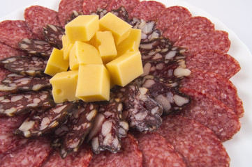 sausage with cheese chopped cubes on a white plate