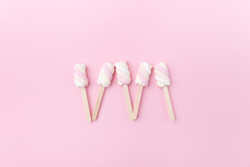 Marshmallows on sticks on tender pink background