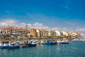 CAMBRILS, SPAIN - APRIL 30, 2017: View of port and city waterfront with Church Of Saint Peter in middle and Torre del Port. Copy space for text.