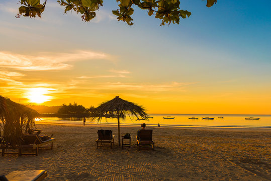 NGAPALI, MYANMAR - DECEMBER 5, 2016: Sunset on the beach, deck chairs with an umbrella. Copy space for text.