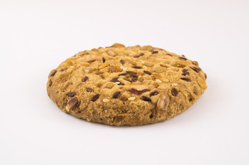 Biscuit covered with sesame seeds and nuts on a light background
