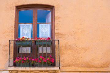 Fototapeta na wymiar TARRAGONA, SPAIN – MAY 1, 2017: European balcony with flowers. Copy space for text.