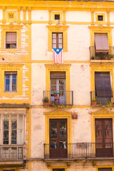 TARRAGONA, SPAIN &ndash; MAY 1, 2017: Facade of Spanish house with balconies and flowers. Close-up. Vertical.
