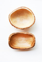Empty wooden bowl on white wooden background.