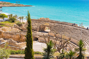 TARRAGONA,SPAIN – MAY 1, 2017: View of the ancient Roman amphitheater, cypress in the foreground....