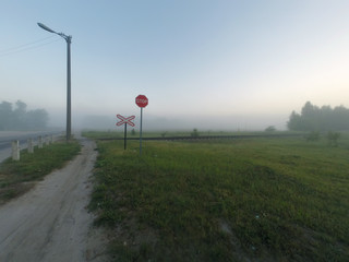 Railway crossing, foggy morning,