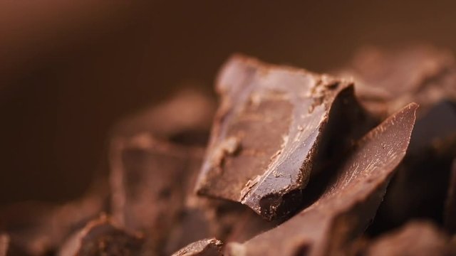 Chocolate. Chunks of sweet dark chocolate rotated closeup. Dessert ingredient. Confectionery. Slow motion 4K UHD video 3840X2160