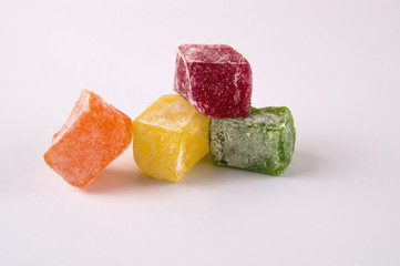 Four slices of lucuma green, red, orange and yellow on a light background