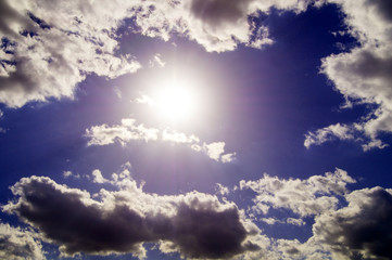 Sun and clouds against the blue sky