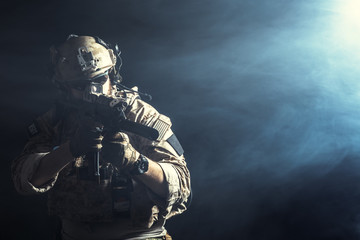 Obraz na płótnie Canvas Special forces soldier with rifle on dark background