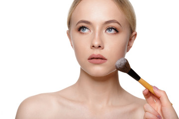 Beauty portrait of a smiling beautiful half naked woman posing with make-up brushes