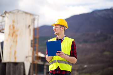 Male construction worker looking at clipboard