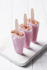Berry ice pops in molds on wooden background