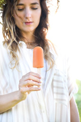 Young woman holding delicious popsicle dessert