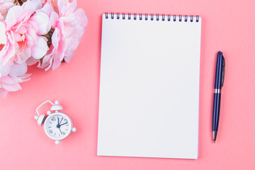 Empty notebook with blue pen on a pink pastel background. mock-up, frame, template.