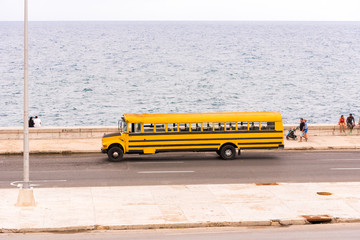 CUBA, HAVANA - MAY 5, 2017: The American school bus rides along the city's waterfront. Copy space...