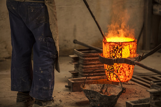 Man preventing coals in blacksmith cauldron