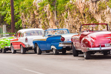 CUBA, HAVANA - MAY 5, 2017: American multicolored retro cars on city street. Copy space for text.